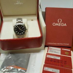 A silver Omega wristwatch with a black face sits in a red Omega box.
