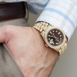 Day-Date Rolex watch on wrist of man.