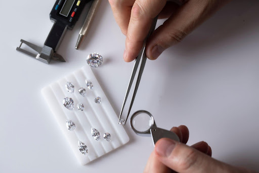 Diamond expert examining loose diamonds under magnifying glass loupe