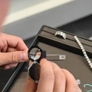 Diamond Banc expert examining a diamond beside its GIA grading report