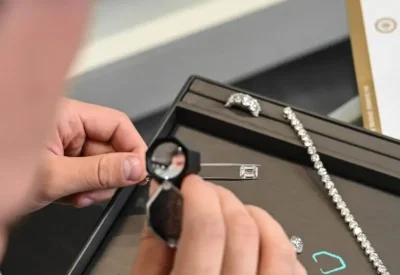 Diamond Banc expert examining a diamond beside its GIA grading report